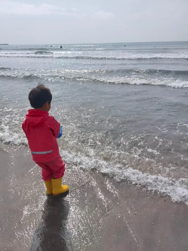 Child gazing at the ocean waves